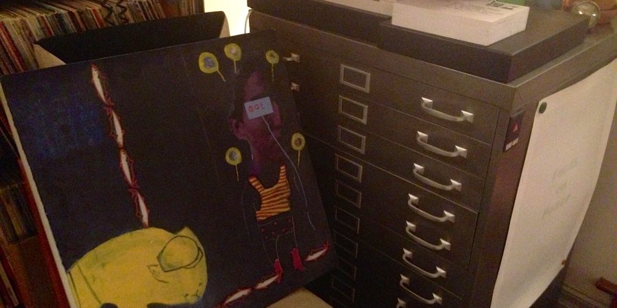 An exquisite corpse painting next to a flat file storage for unhung works on paper.