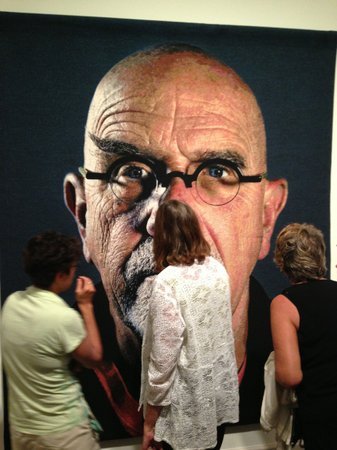 Visitors admire a self-portrait at the opening