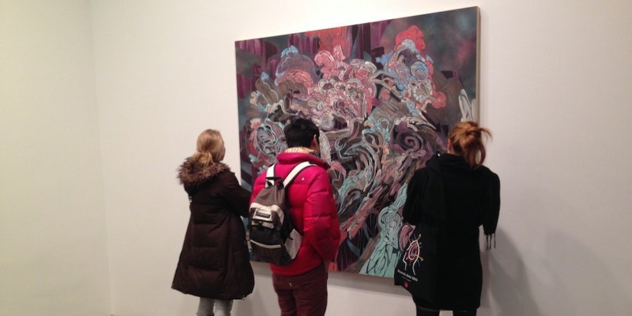 Viewers admiring an Emilio Perez painting