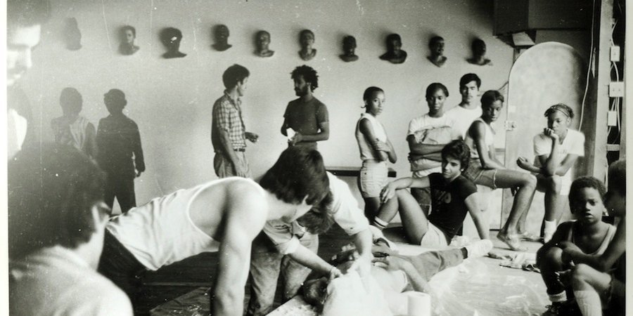 John Ahearn and Rigoberto Torres casting at Fashion Moda in 1979, with an audience of artists and neighborhood kids. Photo by Christoph Kohlhofer