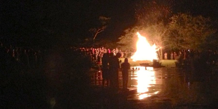 Once the last firework fizzled, a huge bonfire ignited near a lake, where some children watched from a raft. 