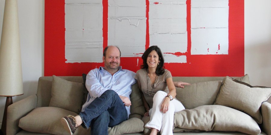 Alon and Betsy Kasha at home with a painting by John Zinsser