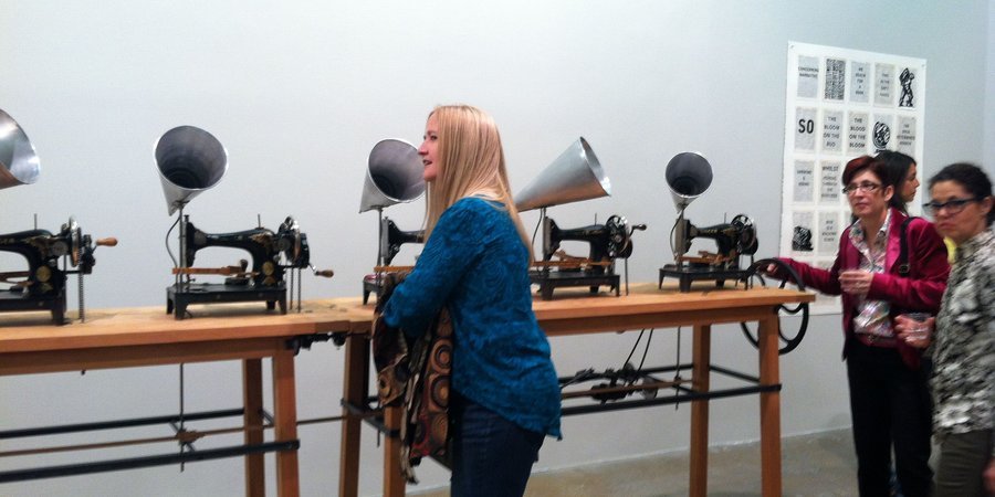 Gallery-goers crank "Untitled (Singer Choir/ Chorus)," 2013, a group of sewing machines attached to megaphones that play music composed by Neo Muyanga.