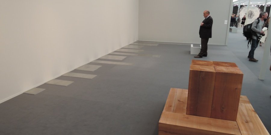 A Carl Andre at Sperone Westwater arranged in formations of one through ten tiles (with another wood sculpture by the artist in the foreground)